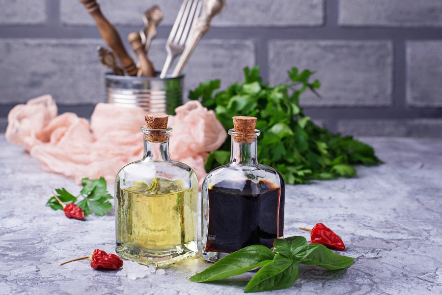 Napełnione butelki octu Obraz nastroju: Dwie wypełnione butelki octu w kuchni, ułożone z przyprawami